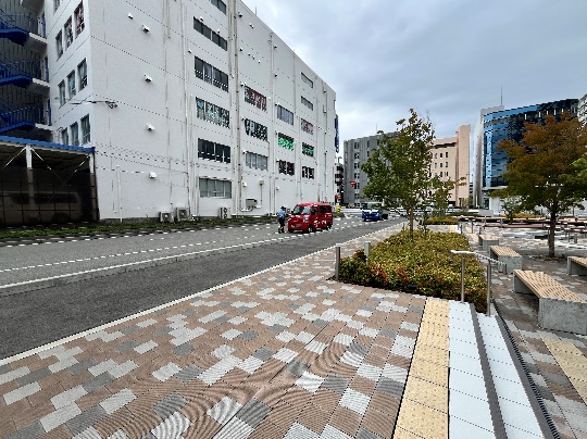 広場の奥に車の停車スペースがあります。そちらでお待ちしております。